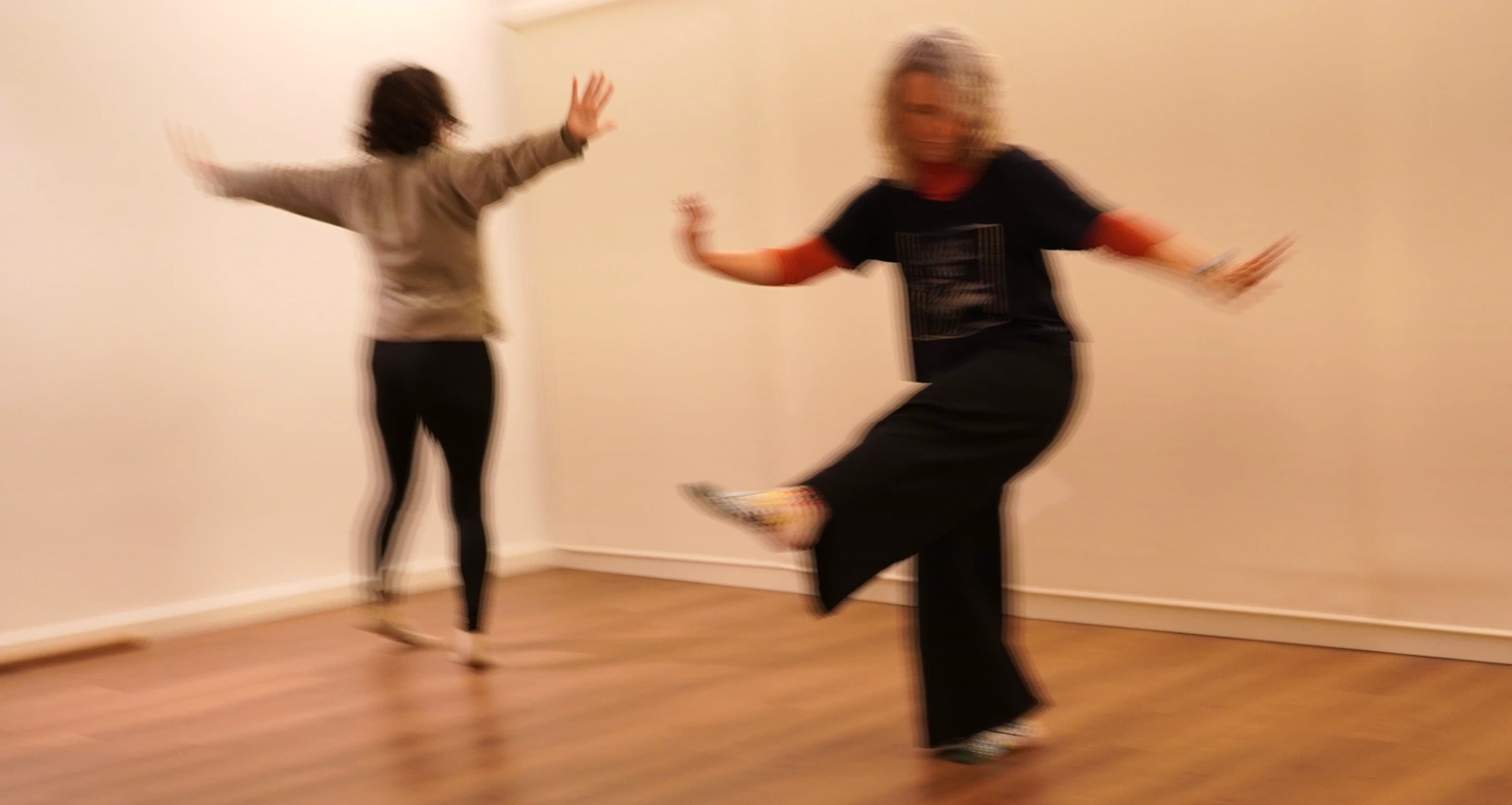 Two people dancing expressively together in a workshop setting